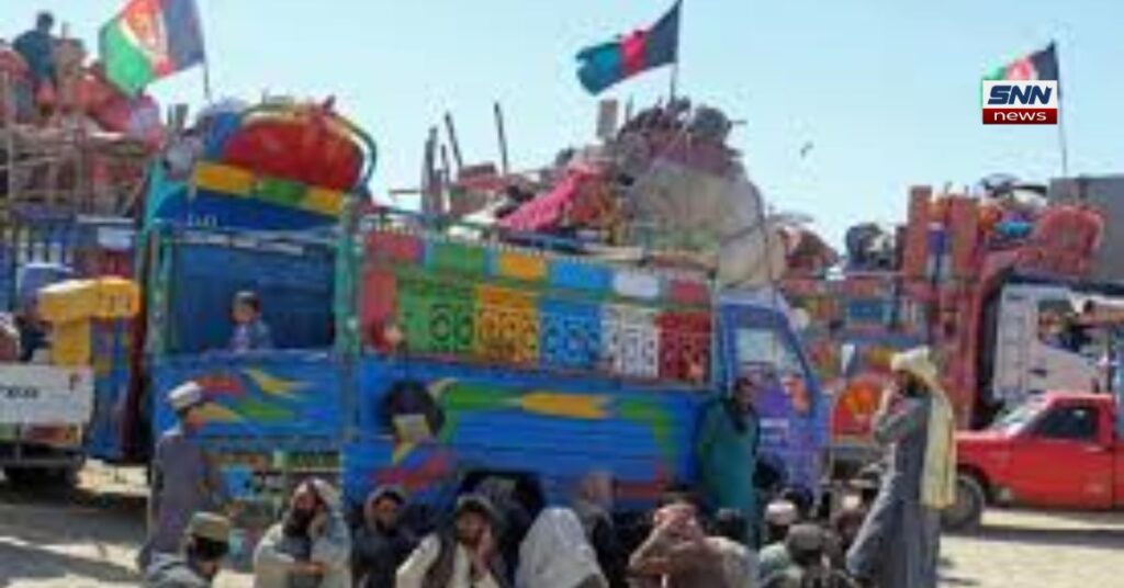 افغانستان کی معاشی صورتحال پر مبنی ایک نیوز انفوگرافک پوسٹر۔ ایک بڑا سائن بورڈ نصب ہے جس پر جلی حروف میں "طالبان حکومت کے بعد معاشی حالات مزید خراب" لکھا ہے۔ بورڈ پر تفصیلی تحریر کے ساتھ مختلف گراف اور خاکہ جات دکھائے گئے ہیں، جن میں گرتا ہوا معاشی گراف، بند بینک (BANK)، بے روزگاری (بے روزگار)، امدادی سرگرمیاں (امدادی سرگرمیاں)، اور مالی مشکلات (مالی مشکلات) کی عکاسی کی گئی ہے۔ پوسٹر کے سامنے مختلف عمر کے افغان شہری اور برقع پوش خواتین گزرتے ہوئے نظر آ رہے ہیں۔ دائیں جانب سیکیورٹی یونیفارم میں ملبوس دو اہلکار گشت کر رہے ہیں۔ پس منظر میں براکہ نیوکلیئر پلانٹ کے گنبد، کولنگ ٹاورز اور دور کھڑی گاڑیاں واضح طور پر دکھائی دے رہی ہیں۔